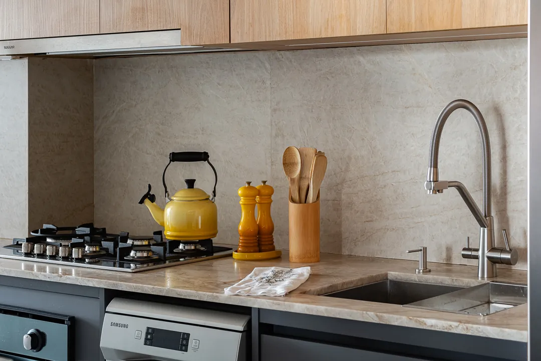 Bancada da cozinha com chaleira amarela e cuba de inox